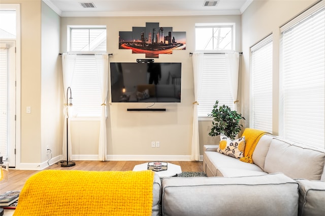 living room with light wood-type flooring and ornamental molding