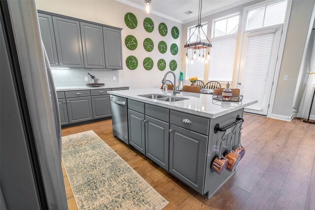 kitchen with dishwasher, sink, crown molding, an island with sink, and gray cabinets