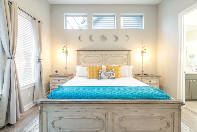 bedroom with light hardwood / wood-style floors and ensuite bath