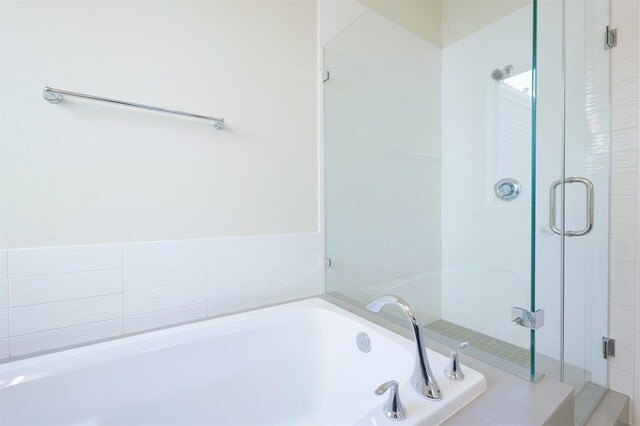 bathroom featuring separate shower and tub