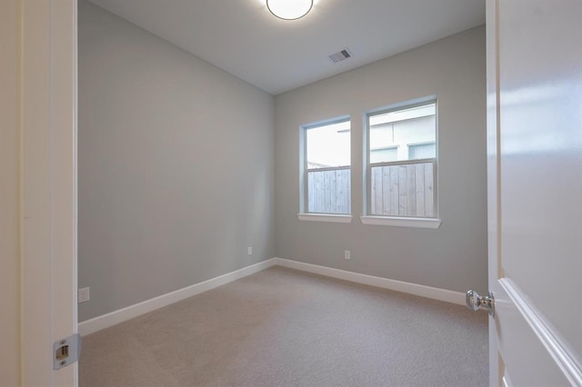 unfurnished room featuring light carpet, visible vents, and baseboards