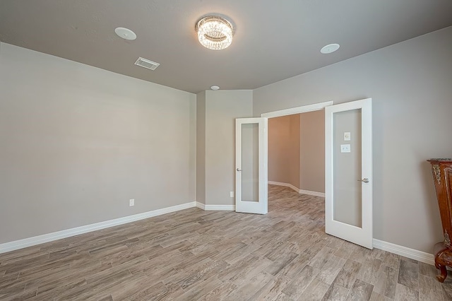 spare room with french doors and light wood-type flooring