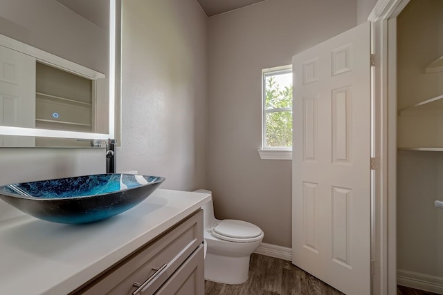 bathroom with hardwood / wood-style floors, toilet, and vanity