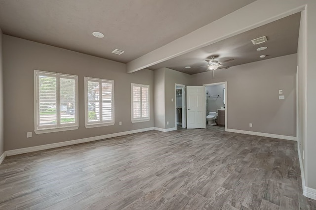 unfurnished living room featuring ceiling fan, hardwood / wood-style flooring, and beamed ceiling