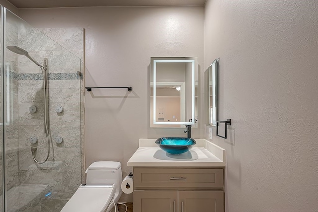 bathroom with toilet, a shower with door, and vanity