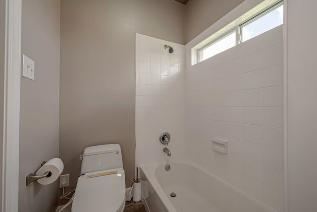 bathroom featuring toilet and tiled shower / bath combo