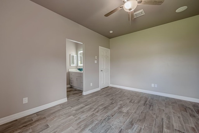 unfurnished bedroom with ceiling fan, light wood-type flooring, and ensuite bathroom