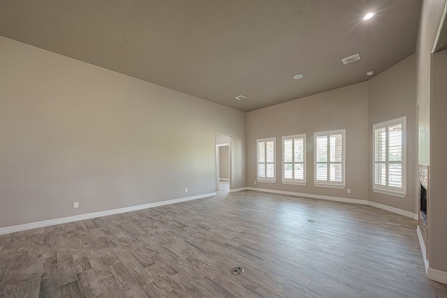 spare room featuring hardwood / wood-style floors and high vaulted ceiling