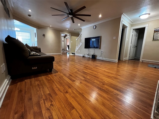 living room with ceiling fan, wood-type flooring, and ornamental molding