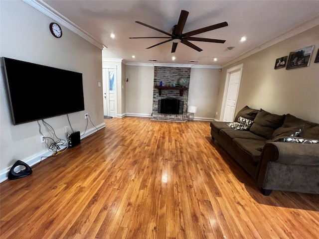 living room with ceiling fan, a fireplace, light wood-type flooring, and ornamental molding