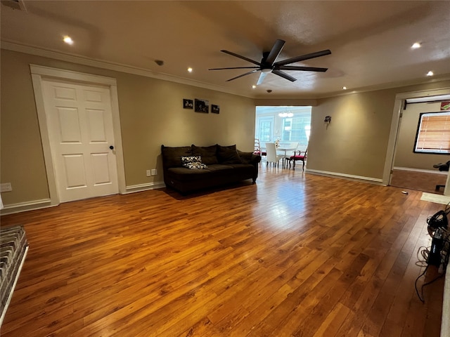 living room featuring ceiling fan, light wood-type flooring, and crown molding