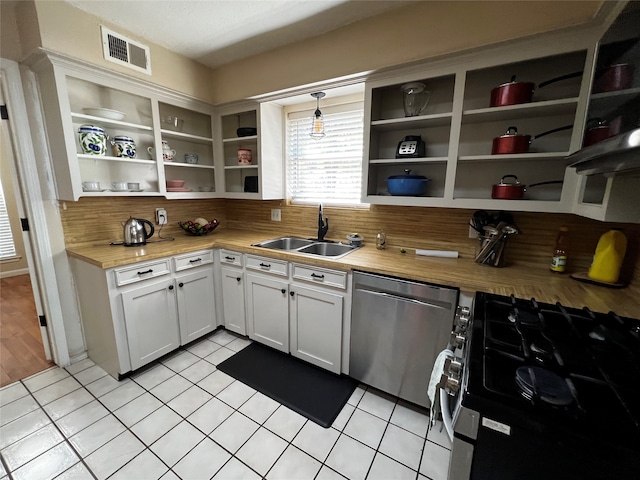 kitchen with backsplash, stainless steel appliances, sink, white cabinetry, and hanging light fixtures