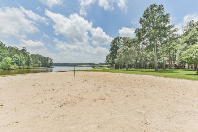 surrounding community with a water view and volleyball court