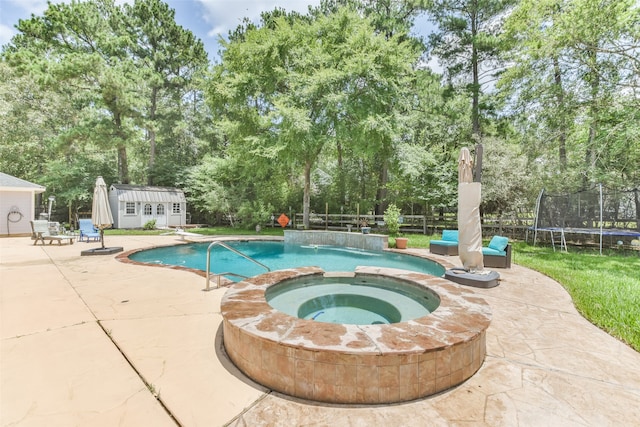 view of swimming pool with a trampoline, an outdoor structure, an in ground hot tub, and a patio