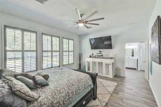 bedroom with light hardwood / wood-style floors, connected bathroom, multiple windows, and ceiling fan