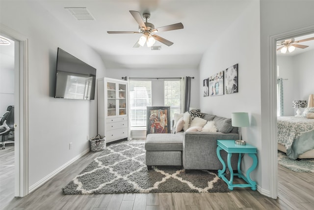 living room featuring lofted ceiling, wood-type flooring, and ceiling fan