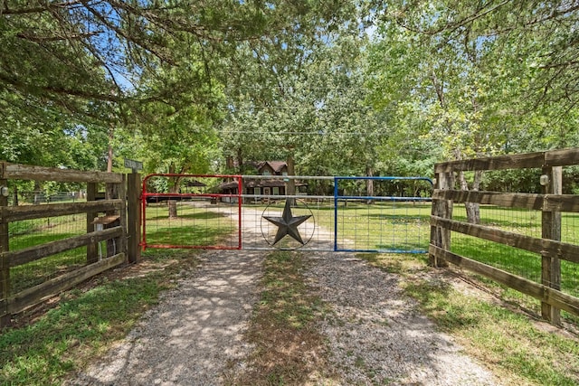 view of gate with a lawn