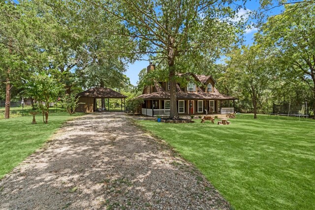 view of front of house featuring covered porch, a carport, and a front yard