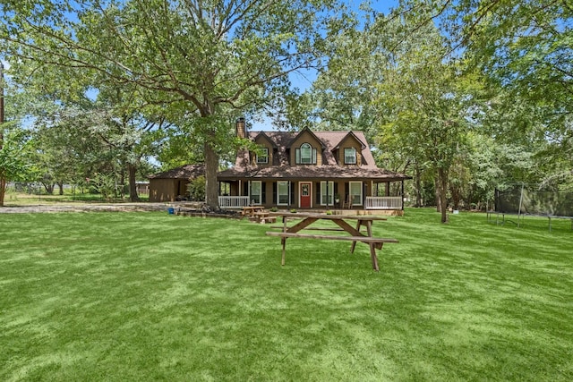 view of front of house featuring a front yard, a trampoline, and a porch