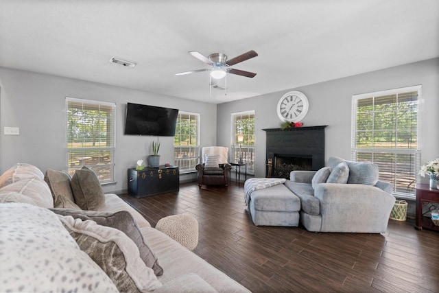 living room featuring ceiling fan, plenty of natural light, and dark hardwood / wood-style flooring