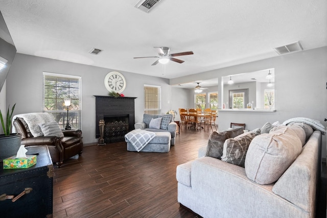 living room featuring a healthy amount of sunlight, dark hardwood / wood-style flooring, and ceiling fan