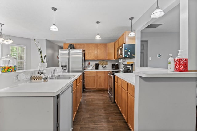 kitchen with appliances with stainless steel finishes, sink, and pendant lighting