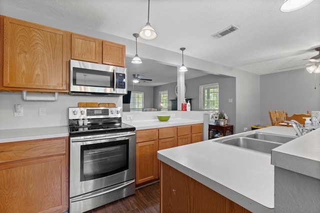 kitchen with ceiling fan, decorative light fixtures, sink, and stainless steel appliances