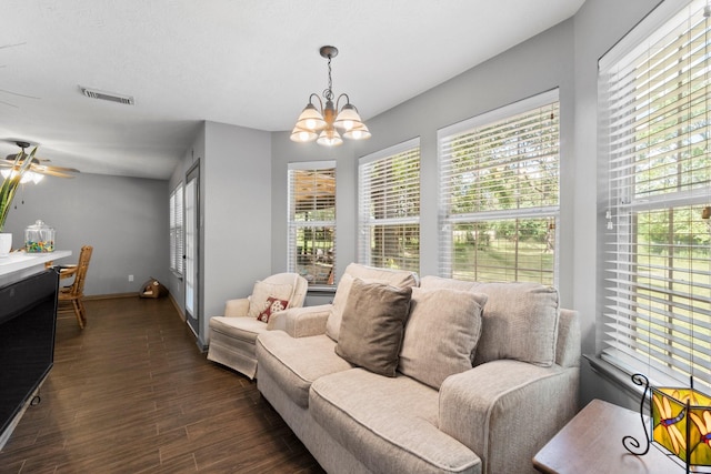 living room with ceiling fan with notable chandelier and dark wood-type flooring