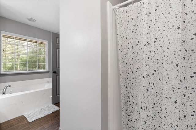 bathroom with hardwood / wood-style flooring and plus walk in shower