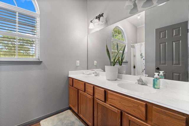 bathroom featuring plenty of natural light, vanity, and curtained shower