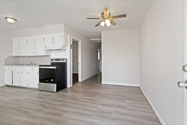 kitchen featuring ceiling fan, decorative backsplash, white cabinets, stainless steel electric range, and light hardwood / wood-style floors