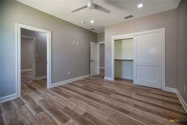 unfurnished bedroom with a closet, ceiling fan, and wood-type flooring