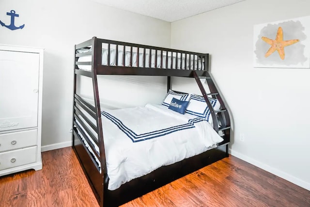 bedroom with a textured ceiling and dark hardwood / wood-style floors