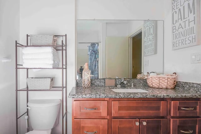 bathroom featuring a shower with curtain, vanity, and toilet