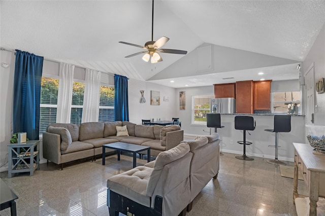 living room featuring ceiling fan, plenty of natural light, high vaulted ceiling, and a textured ceiling