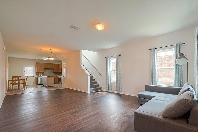 living room with dark wood-type flooring and a healthy amount of sunlight