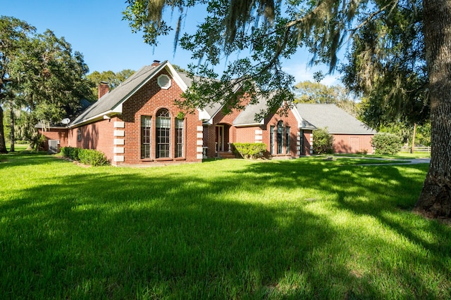 back of property with central air condition unit and a lawn