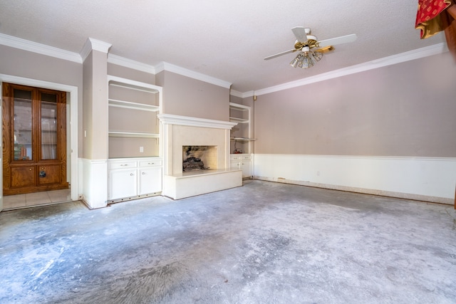 unfurnished living room featuring a textured ceiling, ceiling fan, crown molding, and built in features