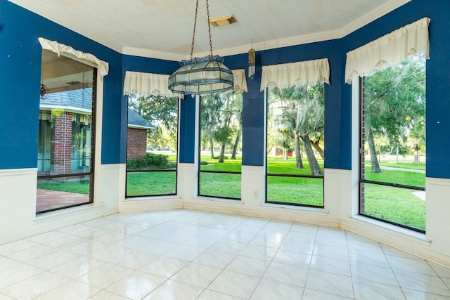 unfurnished dining area with ornamental molding, a textured ceiling, and light tile patterned floors