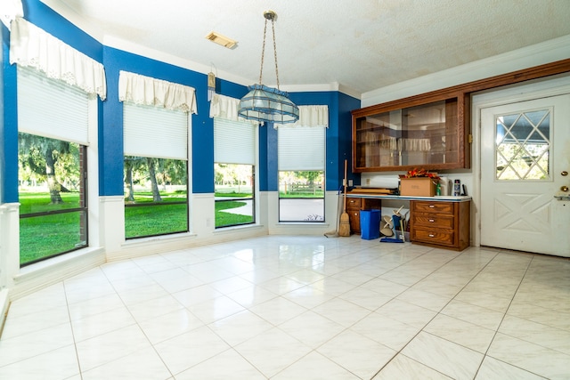 unfurnished dining area with light tile patterned floors, ornamental molding, and a healthy amount of sunlight