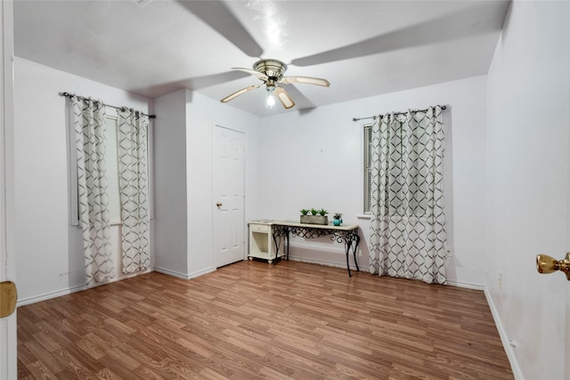 empty room featuring ceiling fan, wood finished floors, and baseboards