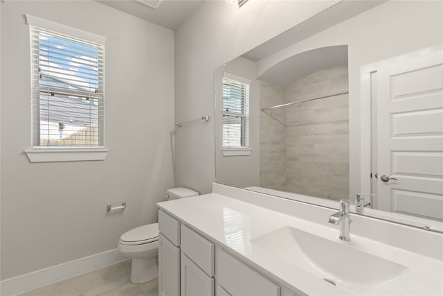 full bathroom with vanity, walk in shower, toilet, and baseboards