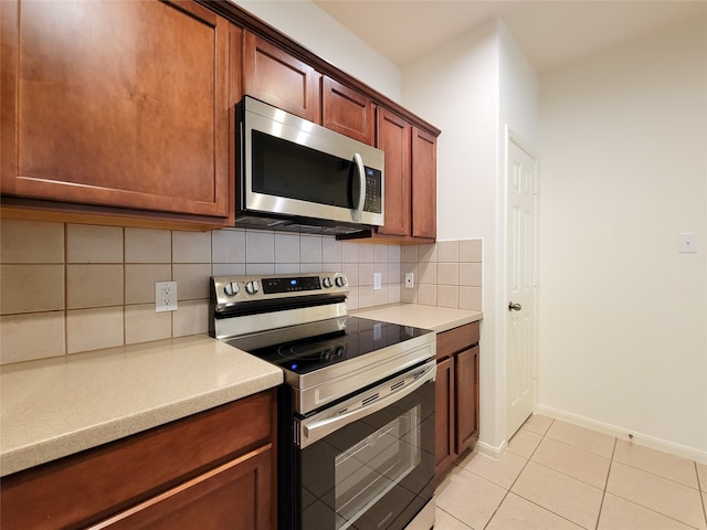 kitchen with stainless steel appliances, decorative backsplash, and light tile patterned floors