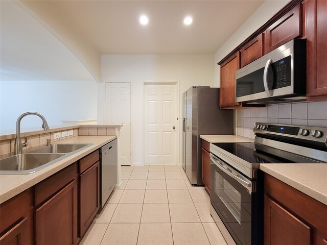 kitchen featuring sink, stainless steel appliances, light tile patterned floors, and tasteful backsplash