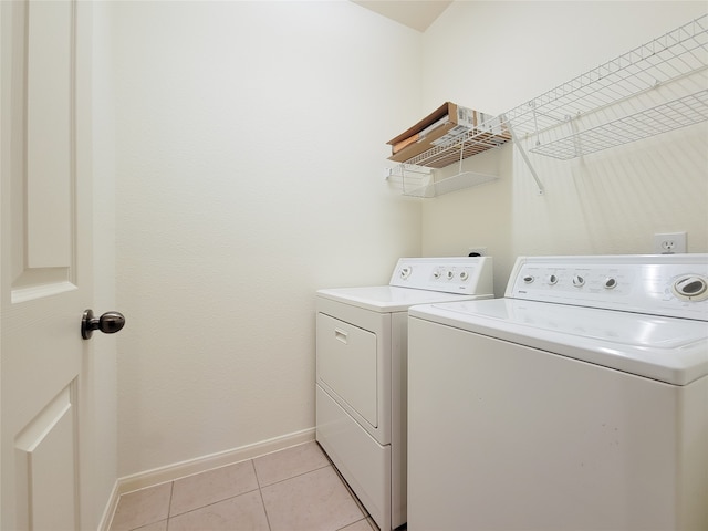 laundry area featuring washer and dryer and light tile patterned floors