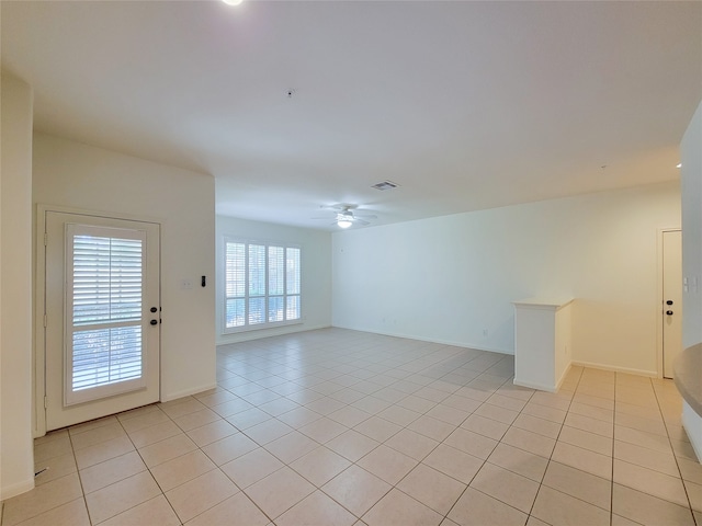 tiled empty room featuring ceiling fan