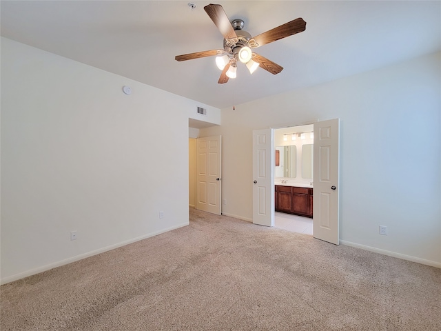 unfurnished bedroom with ceiling fan, connected bathroom, and light colored carpet