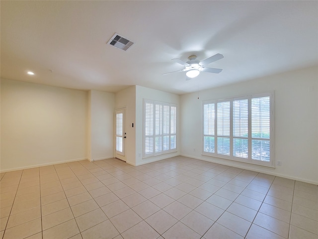 tiled spare room with ceiling fan and a healthy amount of sunlight