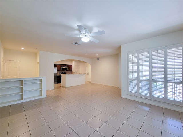 unfurnished living room with light tile patterned floors, a wealth of natural light, and ceiling fan