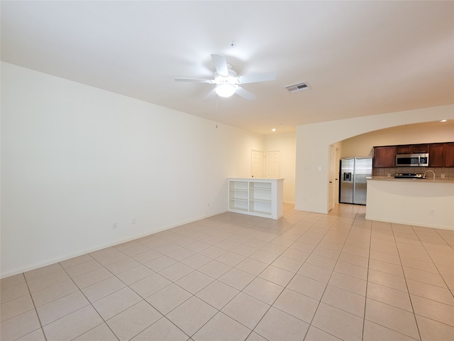 unfurnished living room featuring ceiling fan and light tile patterned floors